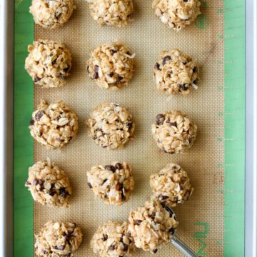 Peanut Butter Energy Balls on a cookie sheet with a scoop.