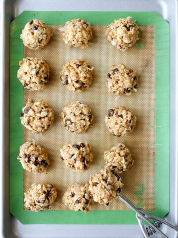 Peanut Butter Energy Balls on a cookie sheet with a scoop.