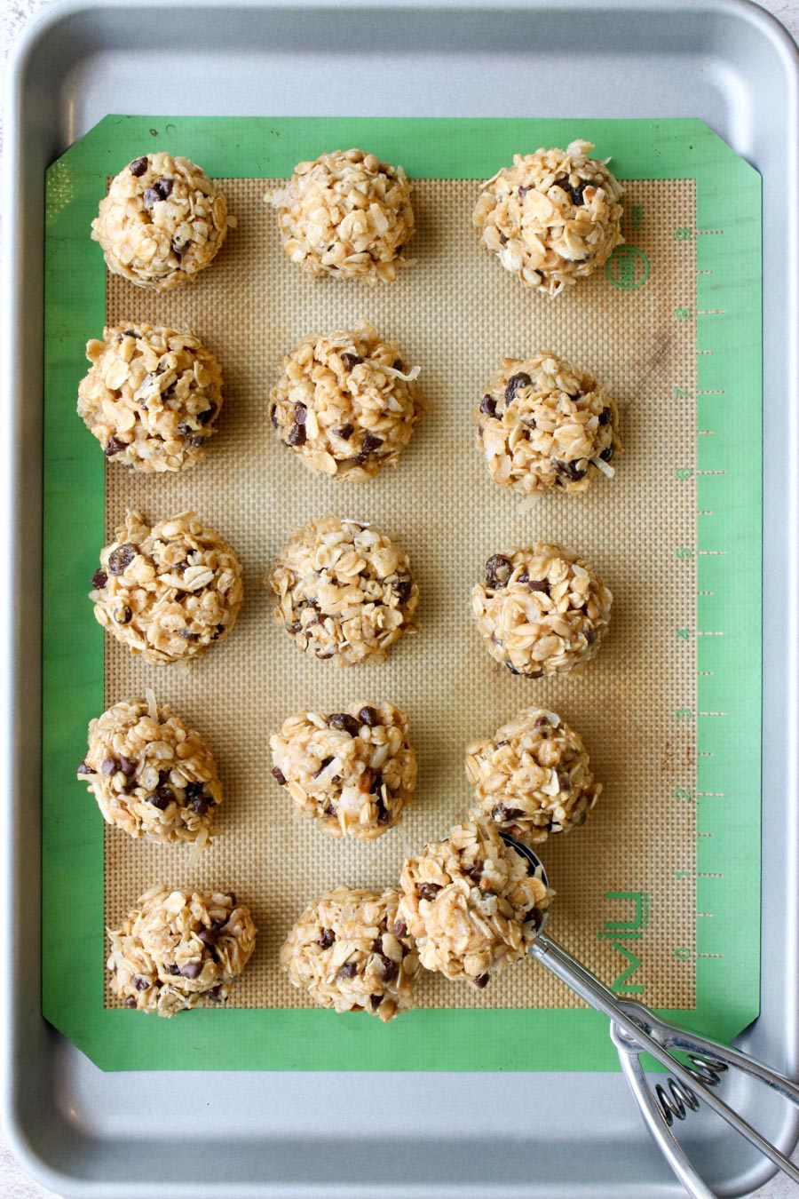 Peanut Butter Energy Balls on a cookie sheet with a scoop.