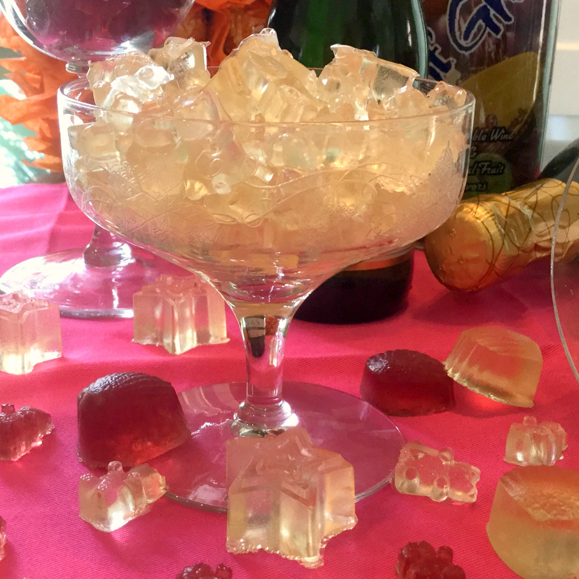 Champagne glass on a pink cloth filled with gummy candy