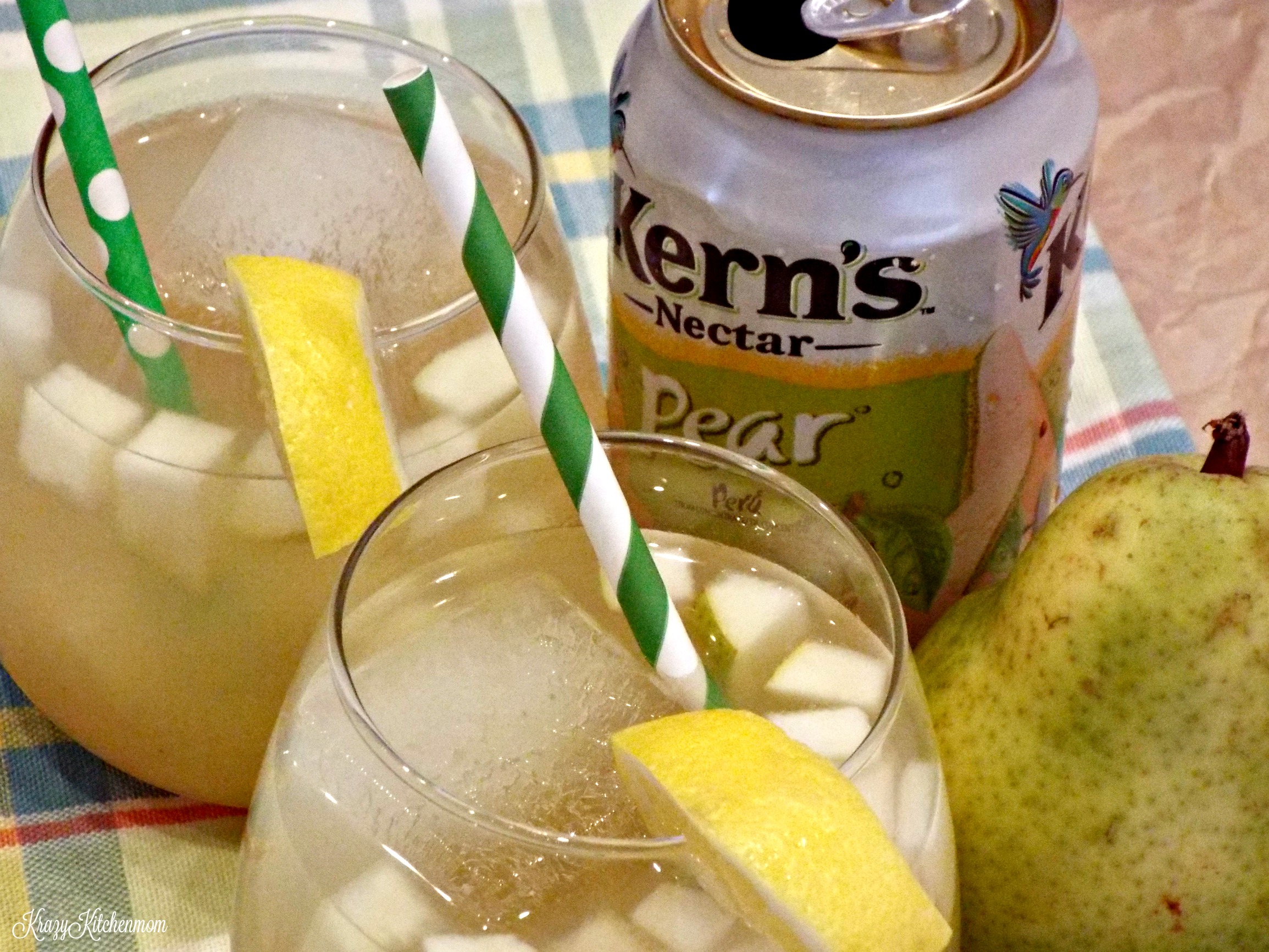 A pear cocktail with a green straw and can in background