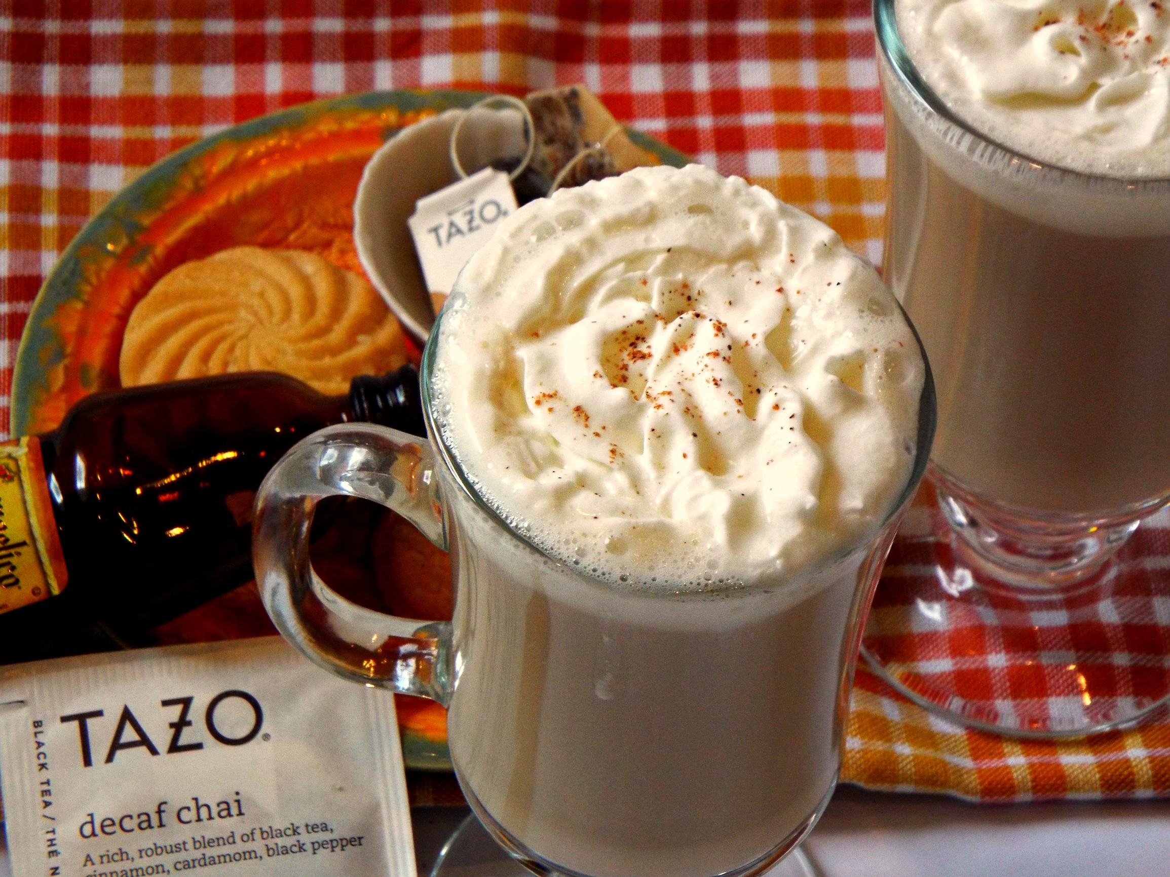 A cup of latte tea topped with whipped cream