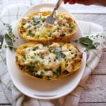 spaghetti squash cooked with person's hand using a fork to take a bite.