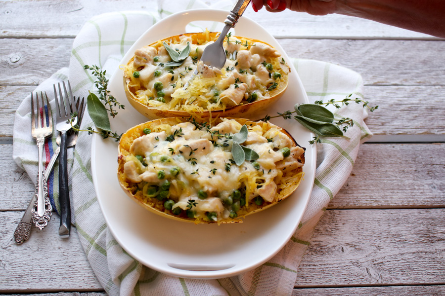 spaghetti squash cooked with person's hand using a fork to take a bite.