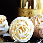 A close up a cupcake on it's side with a gold bottle in background