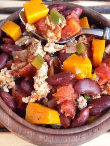 A bowl chili with squash, beans and meat