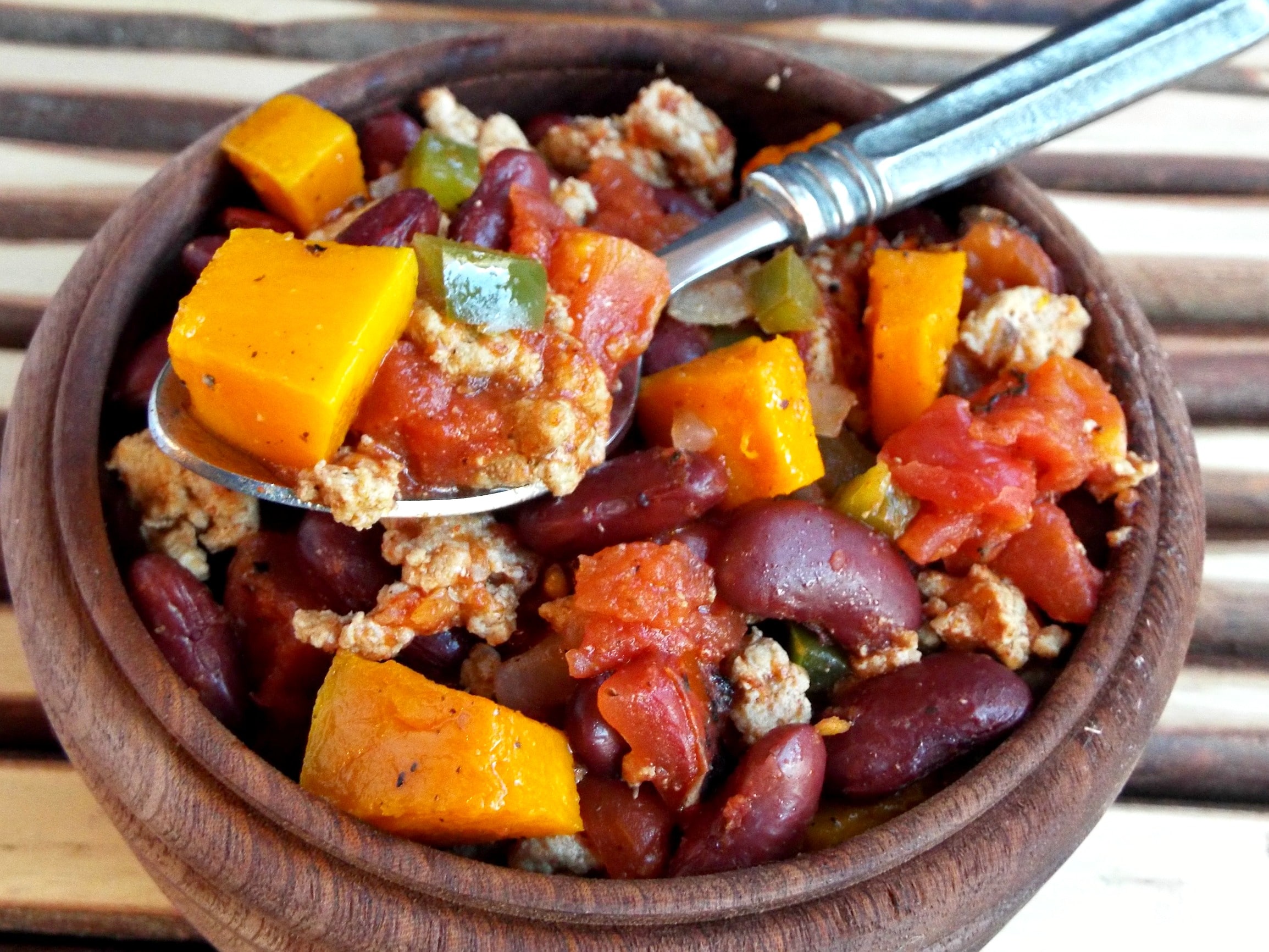 A bowl chili with squash, beans and meat