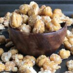 wooden bowl of chickpeas with some spilling out