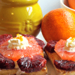 slices of grapefruit and blood oranges with yellow jar in background