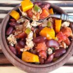 A bowl chili with squash, beans and meat