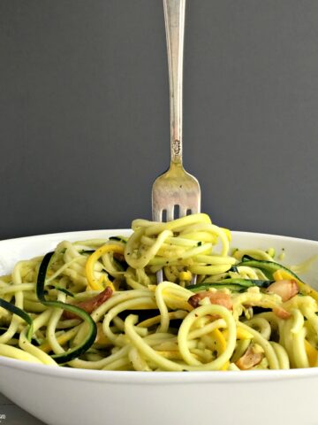 A bowl of swirled squash with a fork standing up in the middle