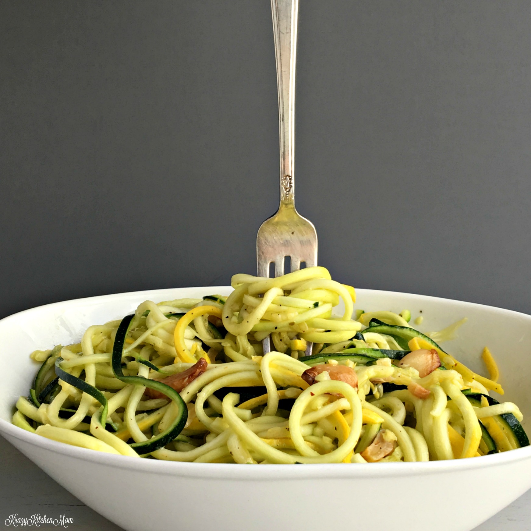 A bowl of swirled squash with a fork standing up in the middle