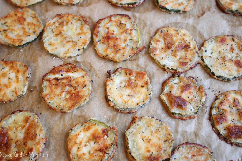 Slices of baked zucchini on a piece of brown parchment paper