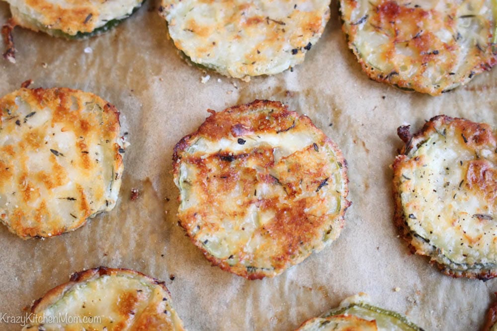 close up of Slices of baked zucchini on a piece of brown parchment paper