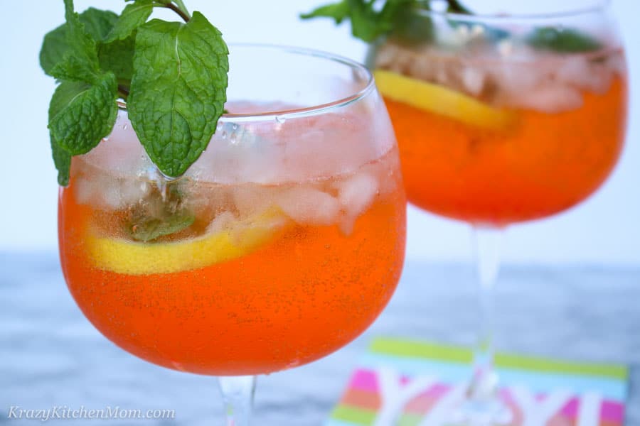 A close up of a glass of orange juice, with Aperol and Prosecco