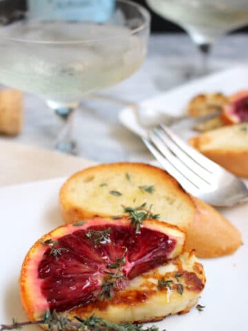 Grilled Halloumi with blood oranges on a plate with bread