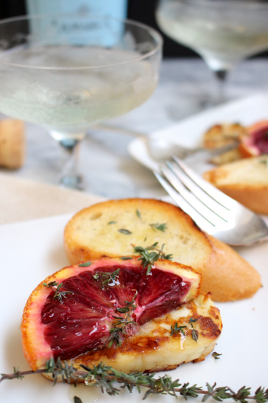 Grilled Halloumi with blood oranges on a plate with bread