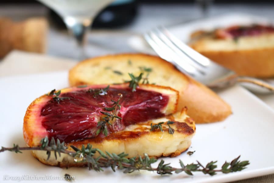 Grilled Halloumi Cheese with Blood Oranges on a plate with a slice of bread