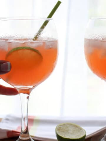 two Paloma Aperol Spritz Cocktails with hand