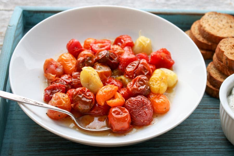 Bowl of roasted tomatoes with a spoon