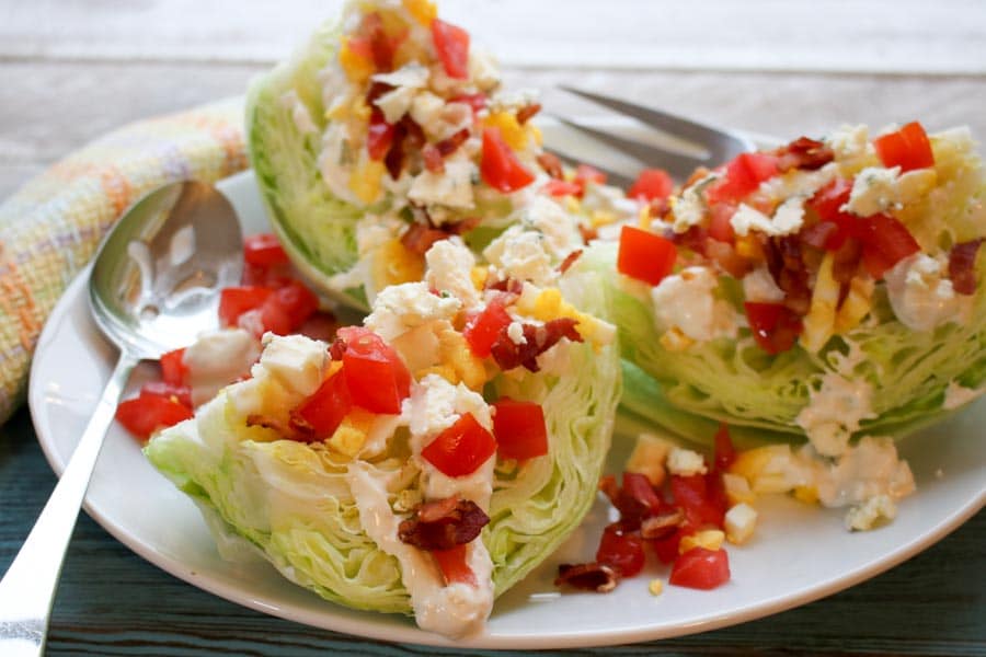 Three slices of classic wedge salad with blue cheese dressing