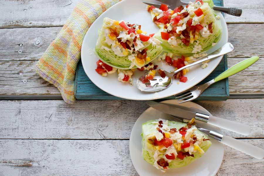 Classic Wedge salad with blue cheese slices and one on a plate