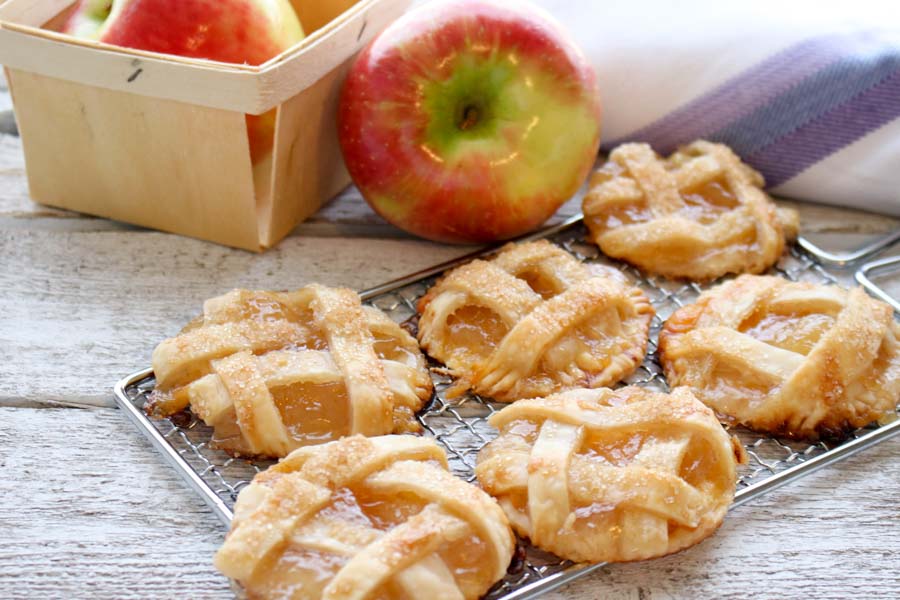 Six Mini Apple Cheddar Pies with an apple 