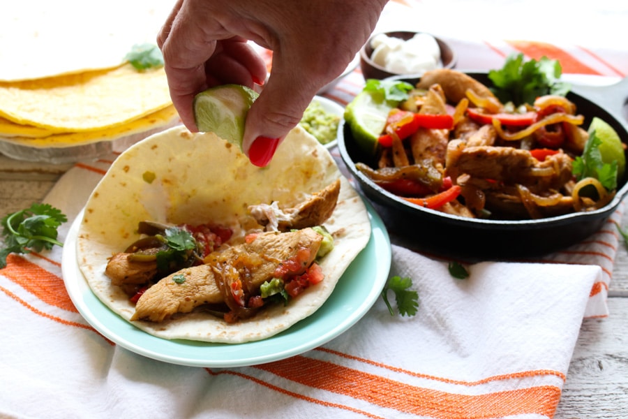 TEQUILA CHICKEN FAJITAS WITH PERSON SQUEEZING LIME JUICE