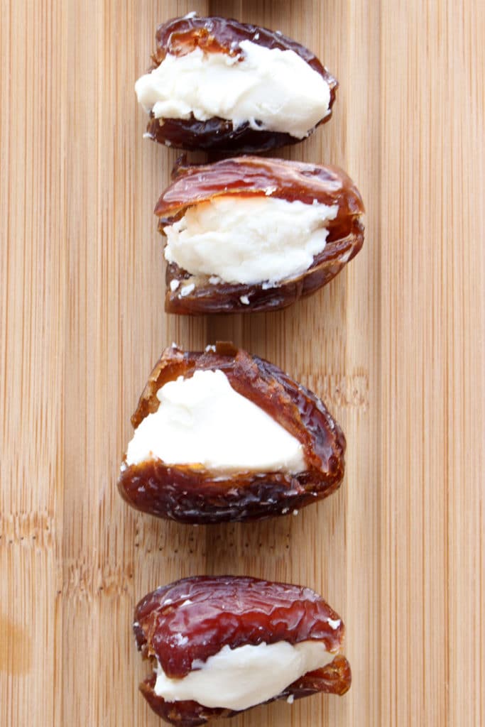 Dates stuffed with cheese on cutting board