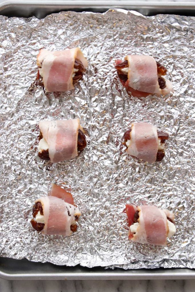 Dates on cookie sheet with foil ready to cook