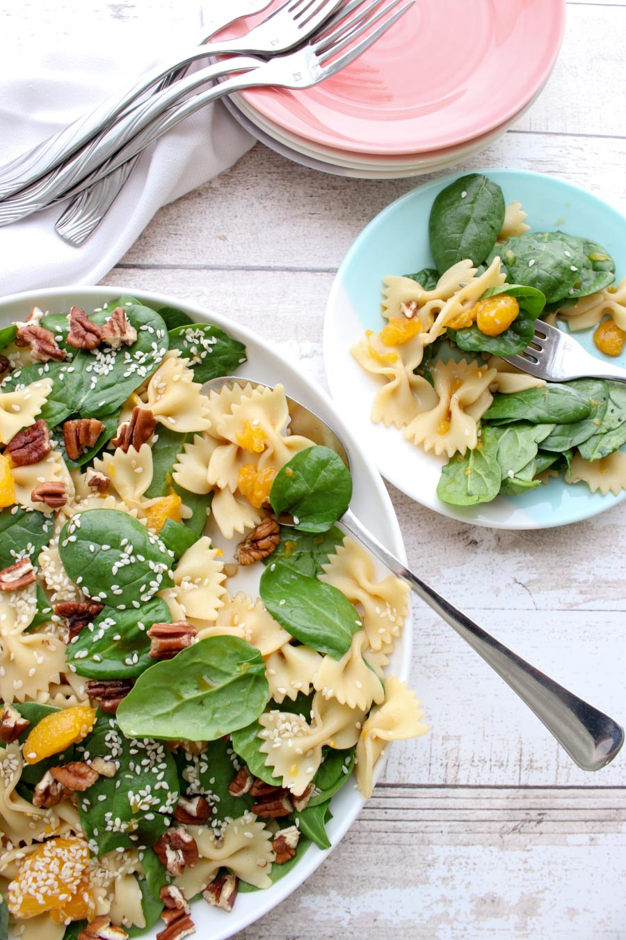 serving bowl and plate of spinach pasta salad