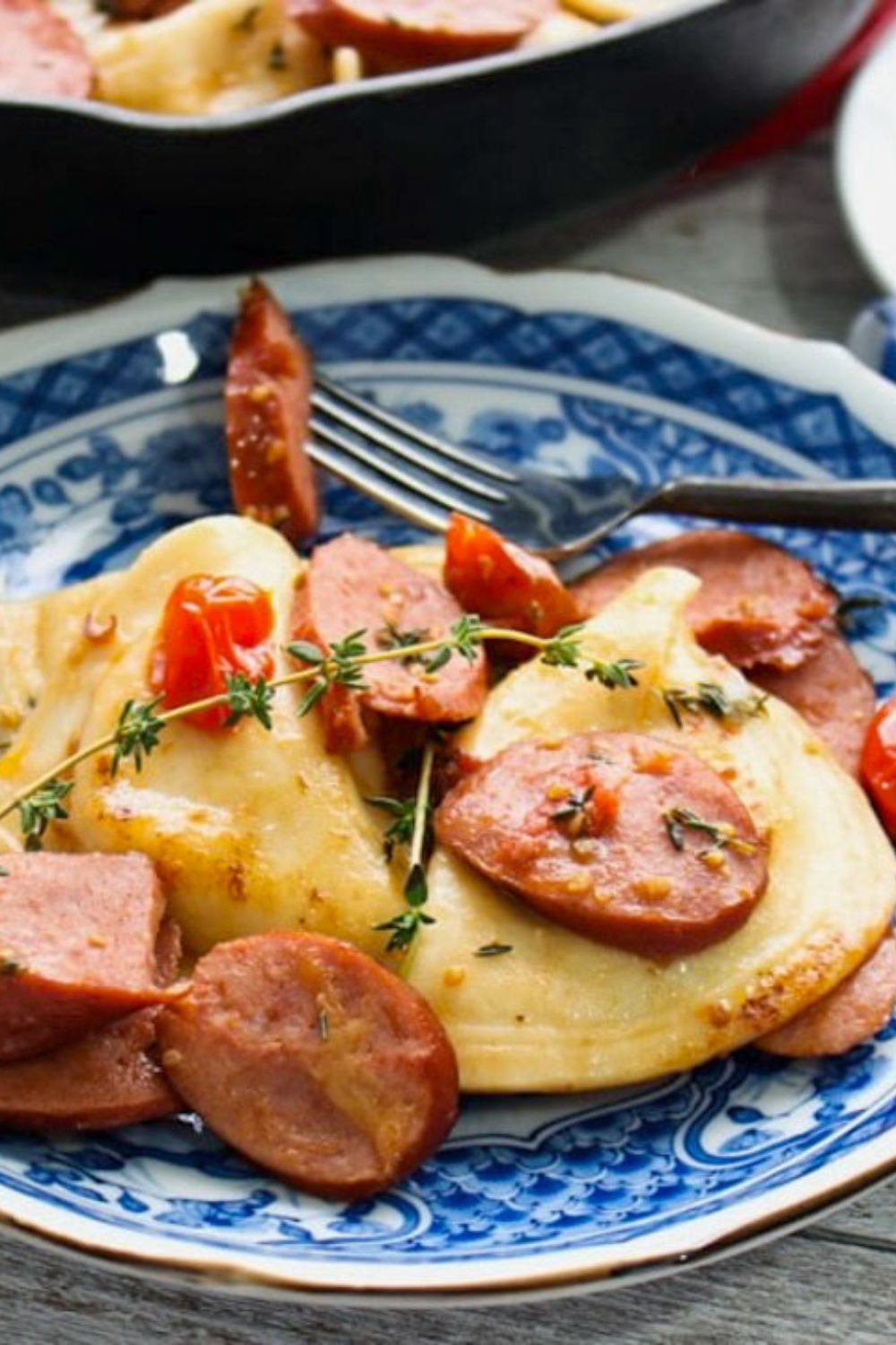 one blue plate with pierogis and  kielbasa