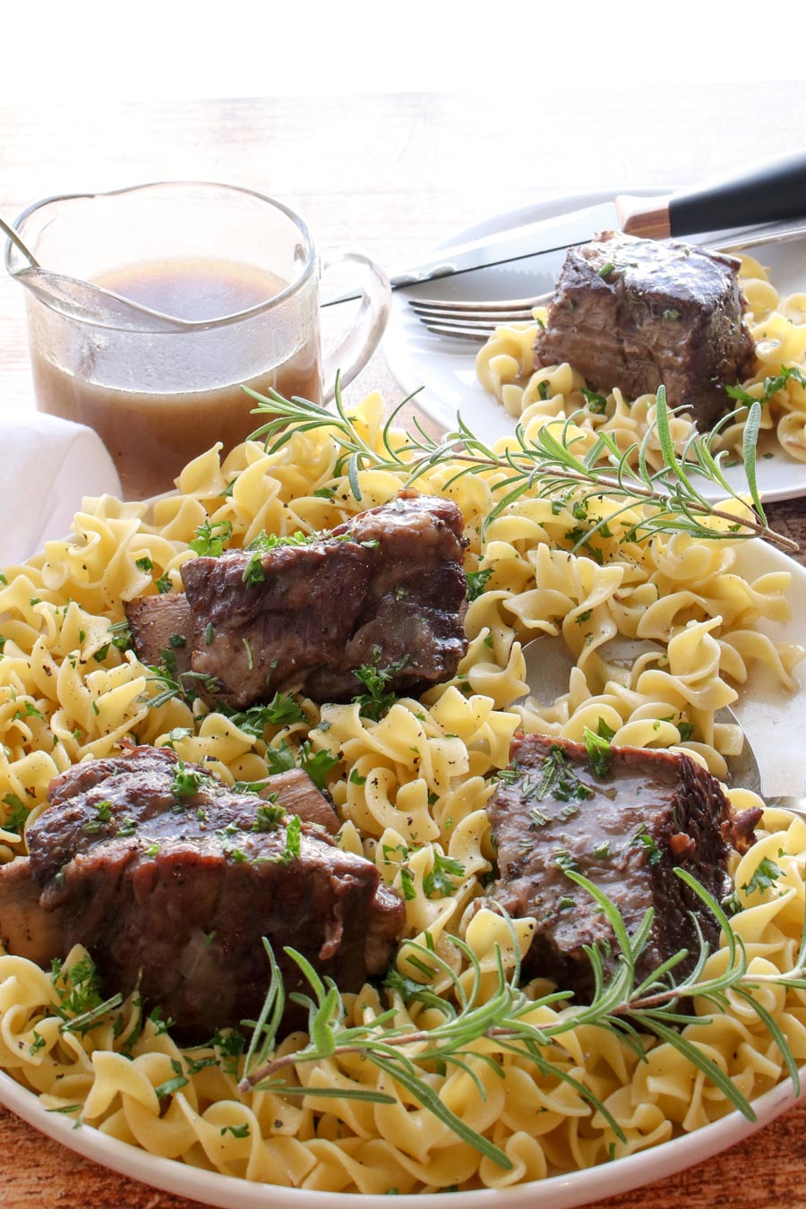 ribs sitting on a plate of noodles