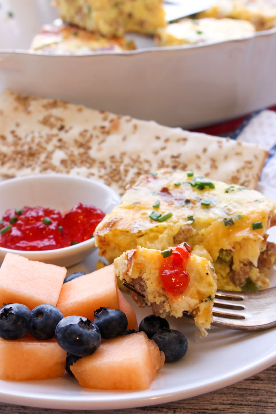 close up of a bite of casserole with red pepper jelly on a fork