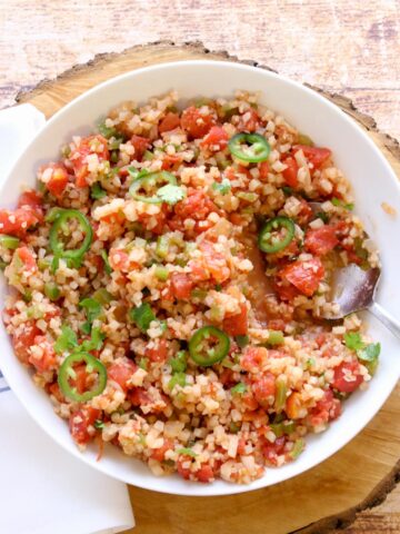 Cauliflower rice in a bowl with a serving spoon