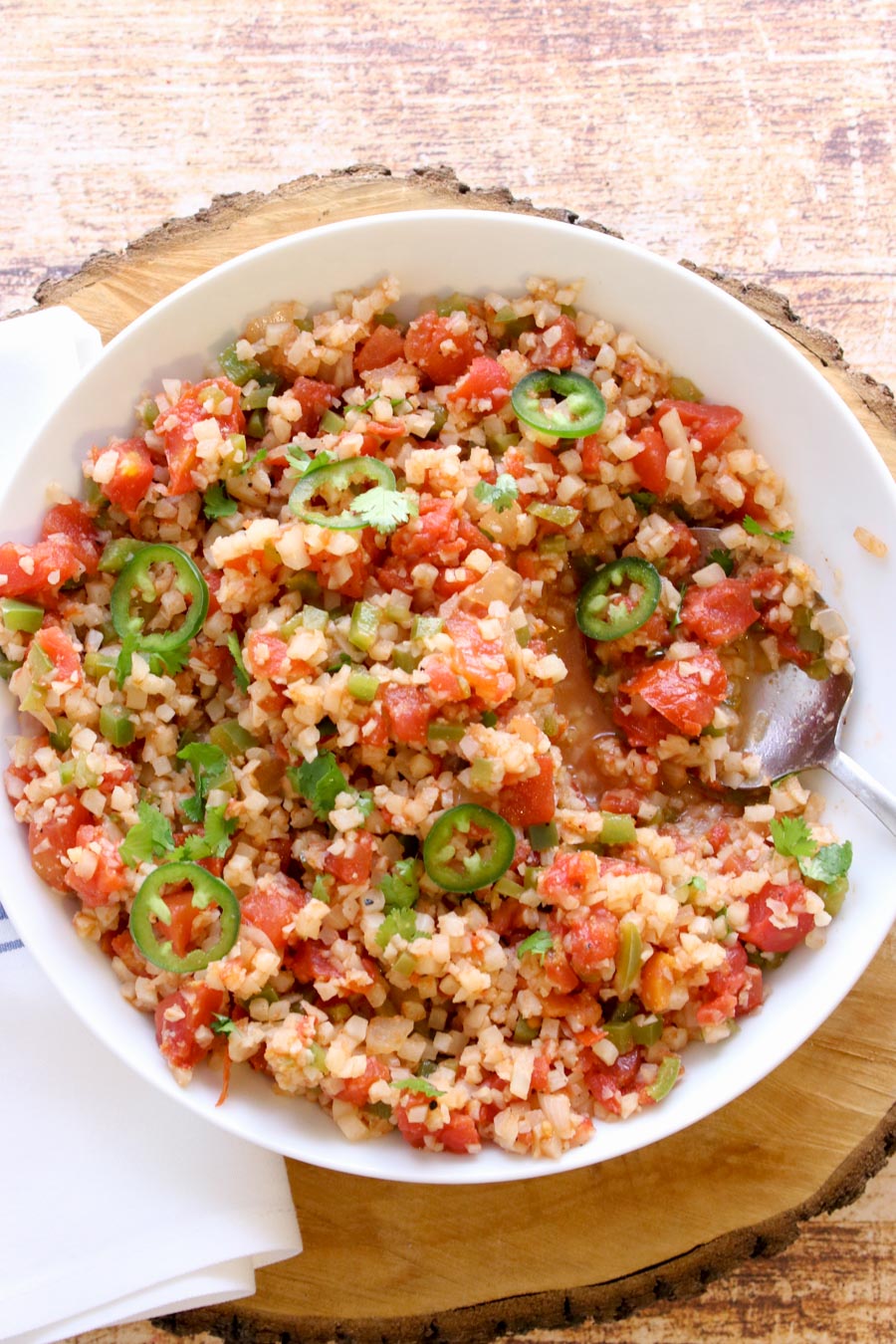 Cauliflower rice in a bowl with a serving spoon