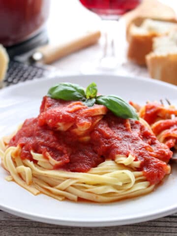 Bowl of sunday sauce on pasta with basil leaf on top