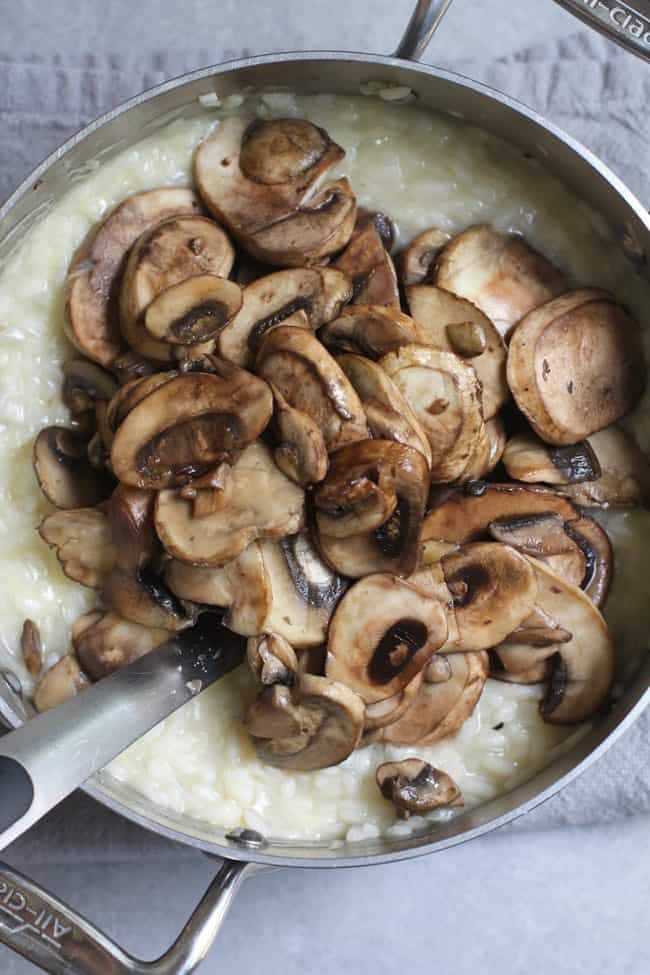 A pan of rice with cooked mushrooms on top