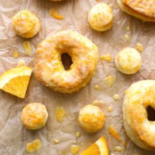 Orange Glazed donuts and donut holes on parchment paper