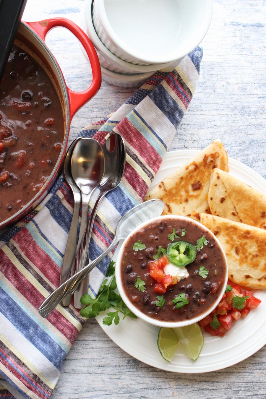 black bean soup in a pot and a bowl with quesadillas on the side