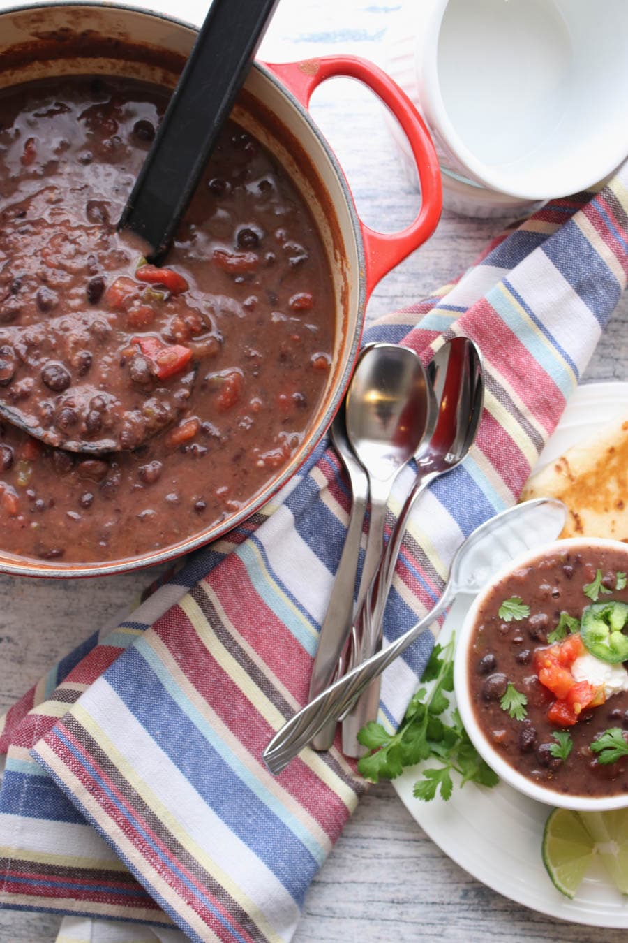 Pot of black bean soup with a bowl of soup in the corner