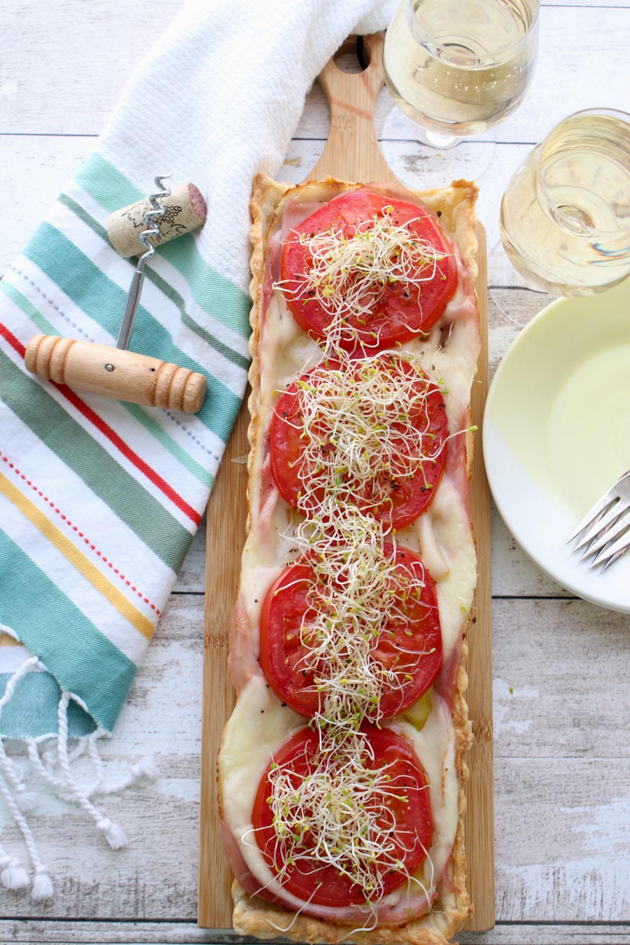 A tomato Tart with a wine glass and cork and cork screw