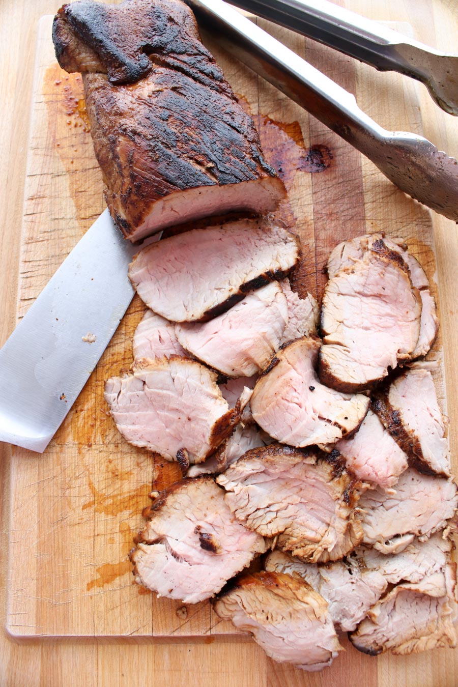 Pork tenderloin on a cutting board with 1/2 sliced off. Ready for the sandwiches.