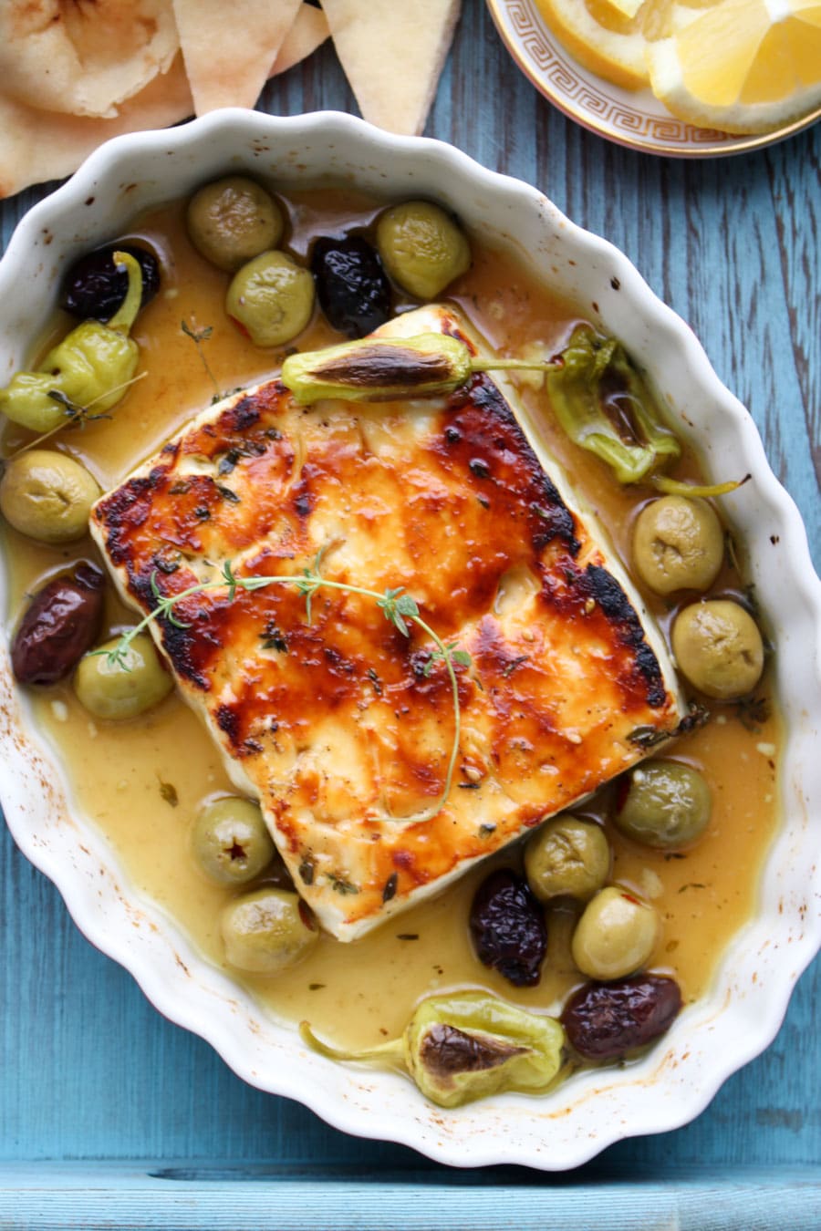 Baked feta in baking dish with olive and olive oil