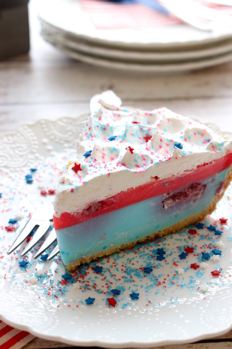A piece of pie with whipped cream and sprinkles on a white plate