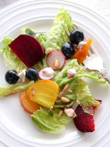 Beet salad on a white plate with a fork