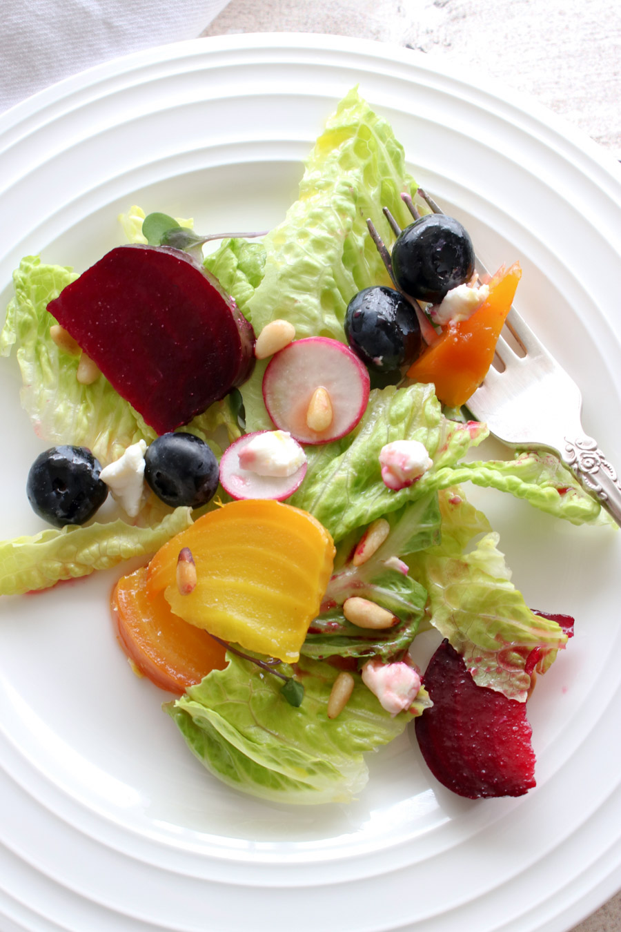 Beet salad on a white plate with a fork