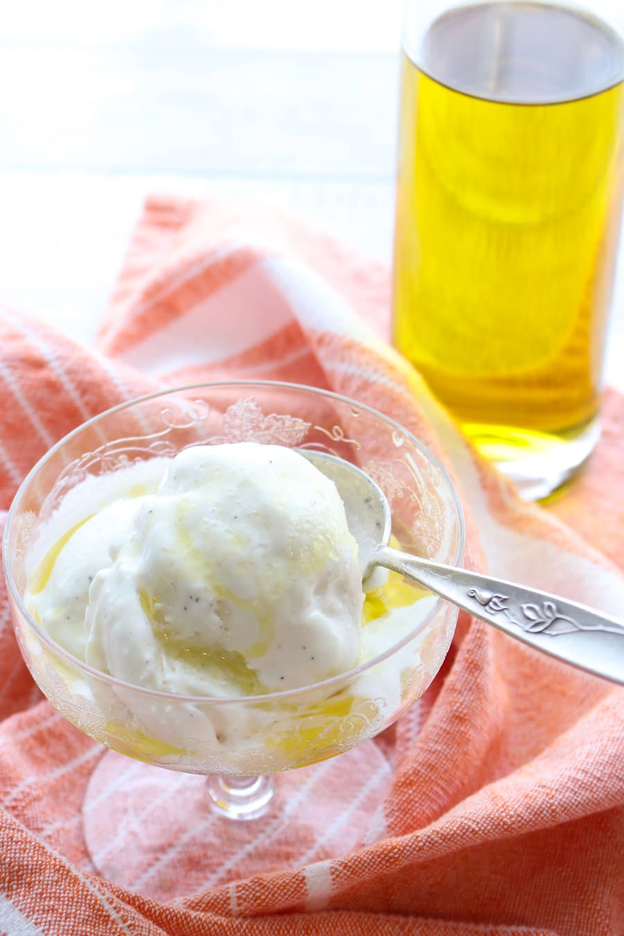 dish of ice cream with olive oil bottle in background