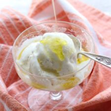 Dish of ice cream with olive oil being poured on it.