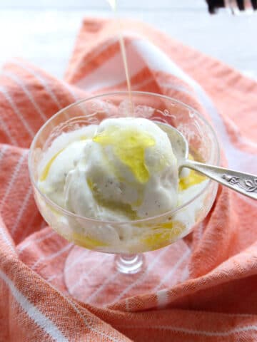 Dish of ice cream with olive oil being poured on it.